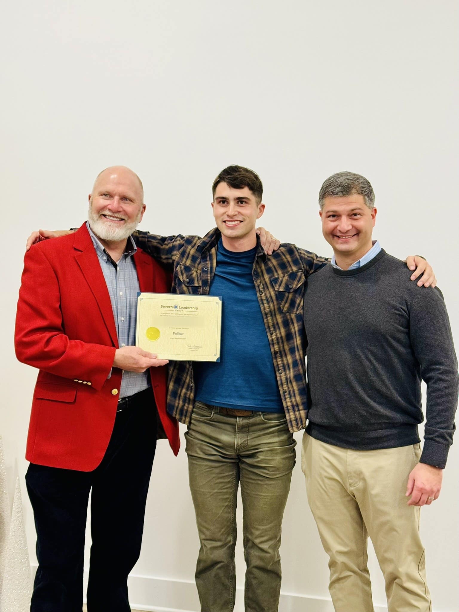 Graduating Fellow and two mentors pose with a certificate at a Severn Leadership Group ceremony