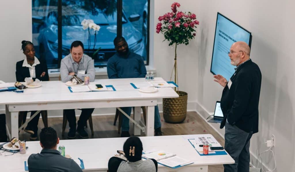 Speaker presents to Fellows seated at tables during a Severn Leadership Group leadership development program