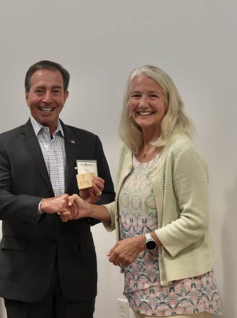 Mentor and Fellow smile and shake hands at a Severn Leadership Group event