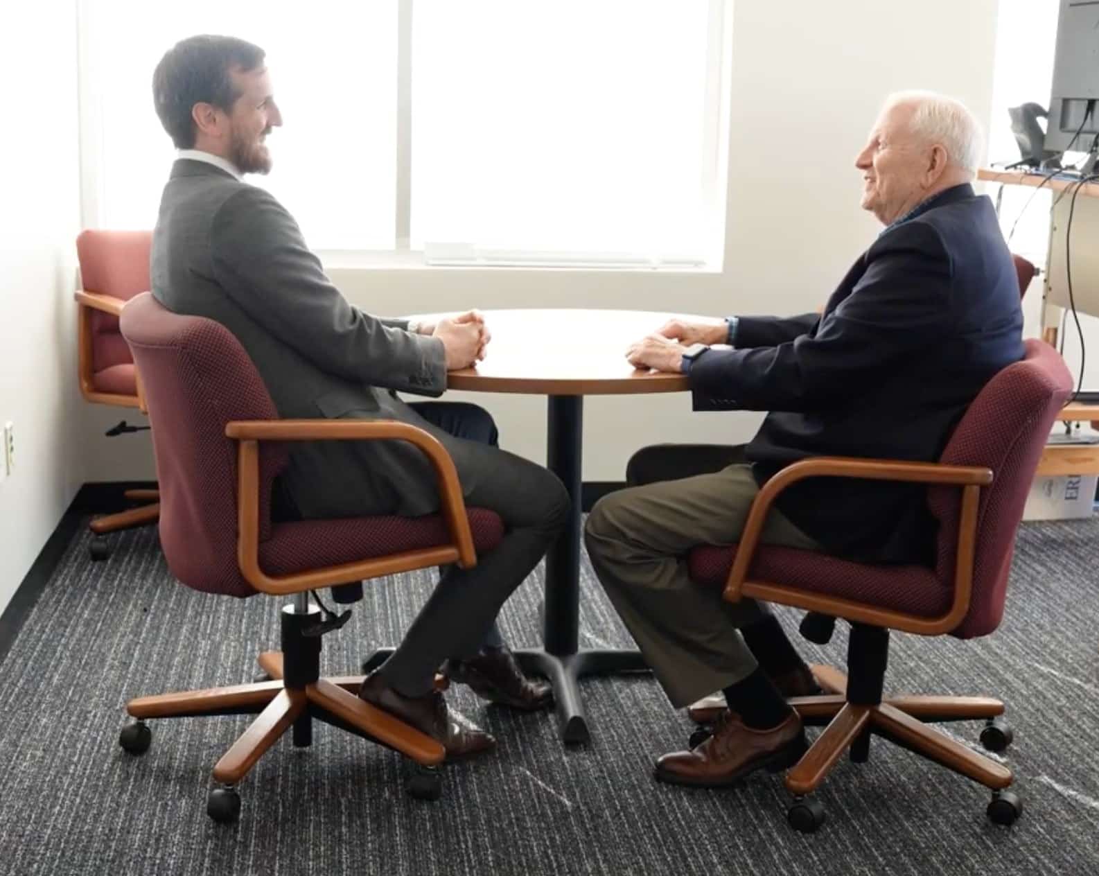 Mentor and Fellow meet one on one across a table in an office during a leadership mentoring session