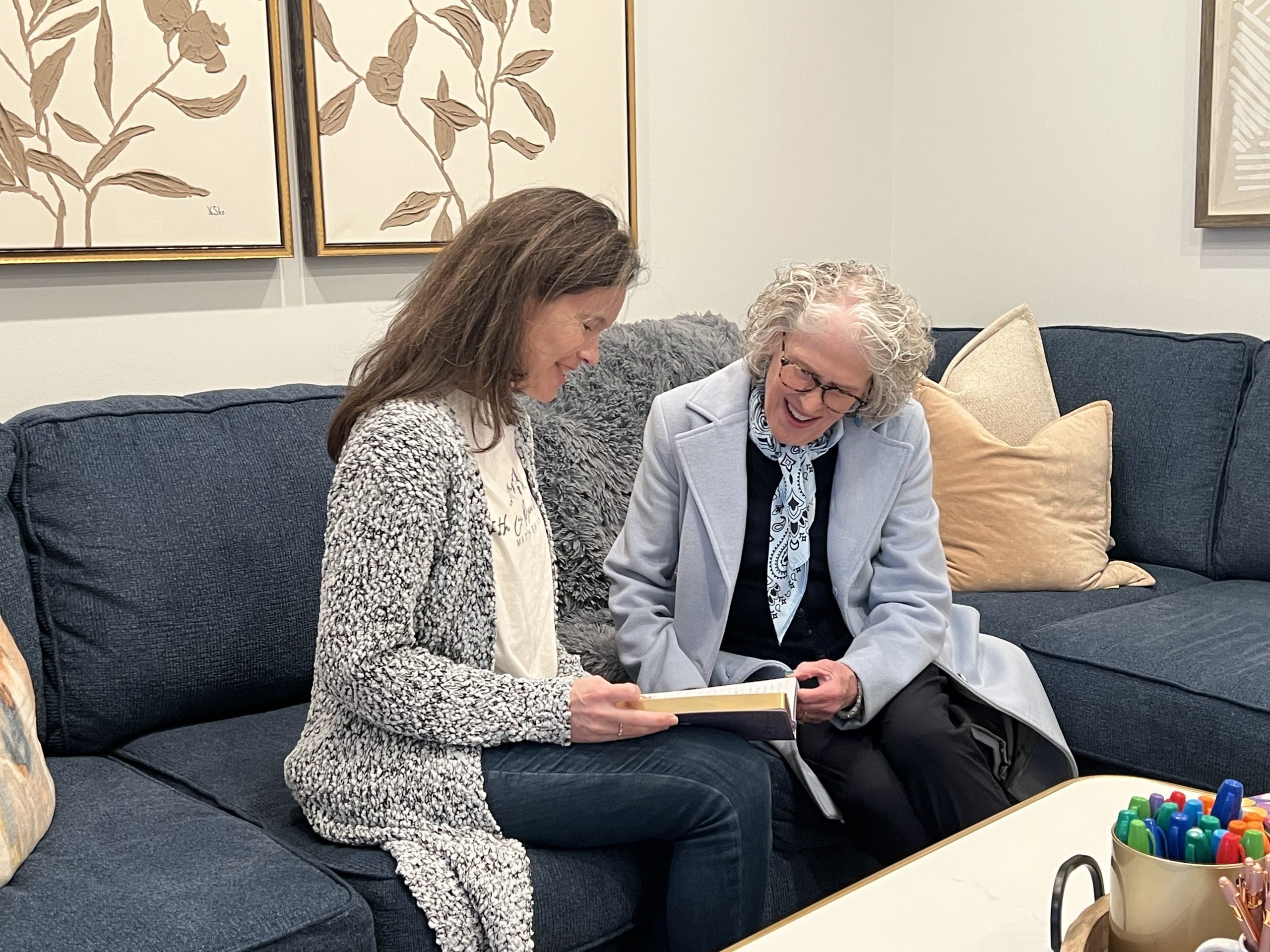 Mentor and Fellow review materials together on a couch during a one-on-one Severn Leadership Group mentoring session